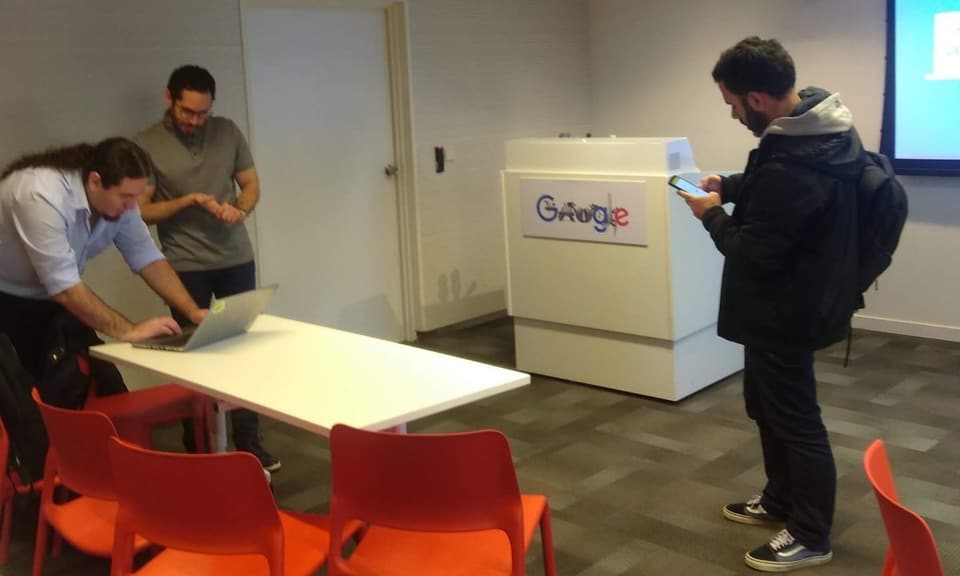 Sala de las oficinas de Google Argentina durante el Google Tagathon, con el atril de Google y participantes preparando sus equipos.
